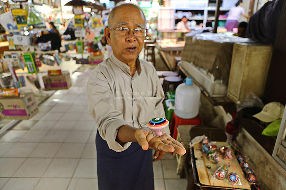 Yangon man selling home made spinning tops