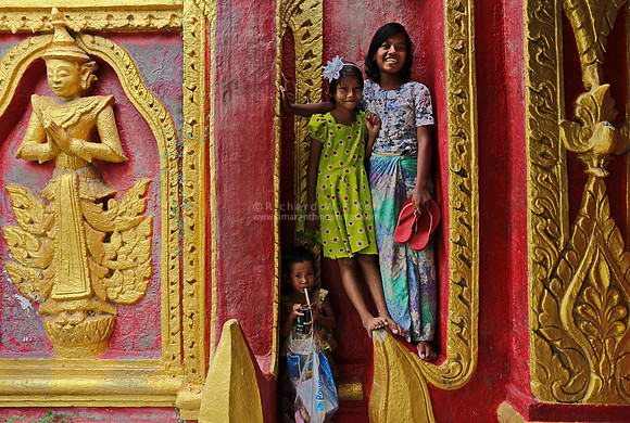 Mandalay Kuthodaw Paya kids on a wall with nat statue