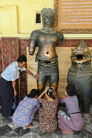 Mandalay Mahamuni Paya women devotees touching Khmer bronze statue of Shiva